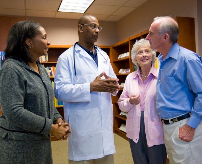 senior couple talking to their doctor and patient navigator