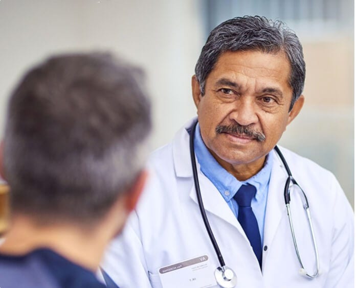 ethnic doctor wearing stethoscope having conversation with patient