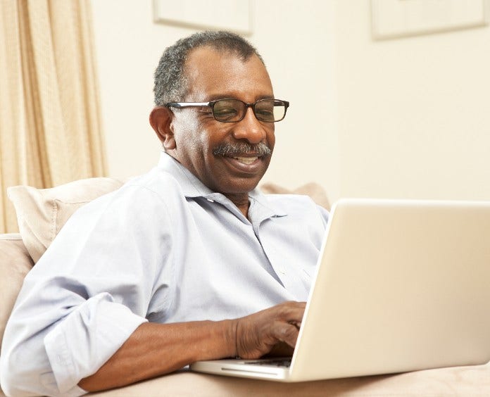 smiling senior man uses laptop